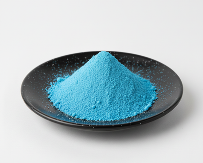 Blue powder on a black plate with a white background