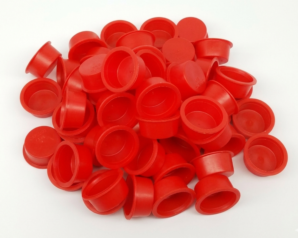 Pile of red plastic caps on a white background