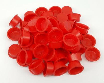 Pile of red plastic caps on a white background